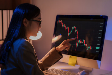 Businesswoman analyzing declining stock market chart on computer screen