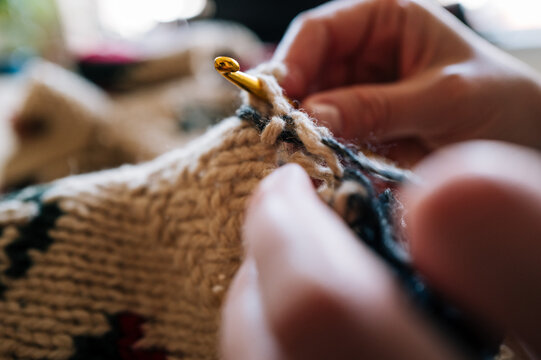 Close-up of crochet hook unraveling yarn