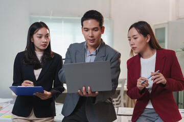 Business team analyzing data on laptop in office meeting