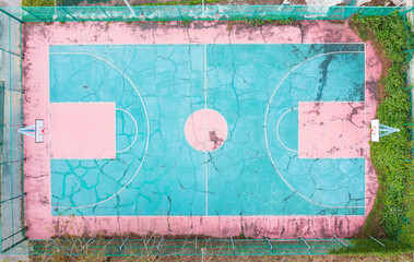 Old and Weather beaten Basketball Court with Turquoise and Pink 