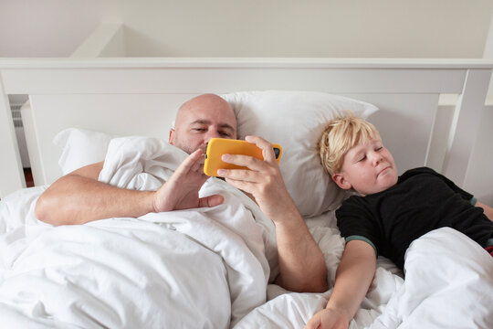 a woken man chilling on his phone with his son