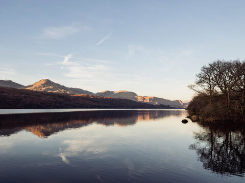 Calm scene of lake and mountains at sunset