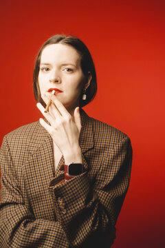 Young Woman in Vintage Blazer with Negative Space on Red Background