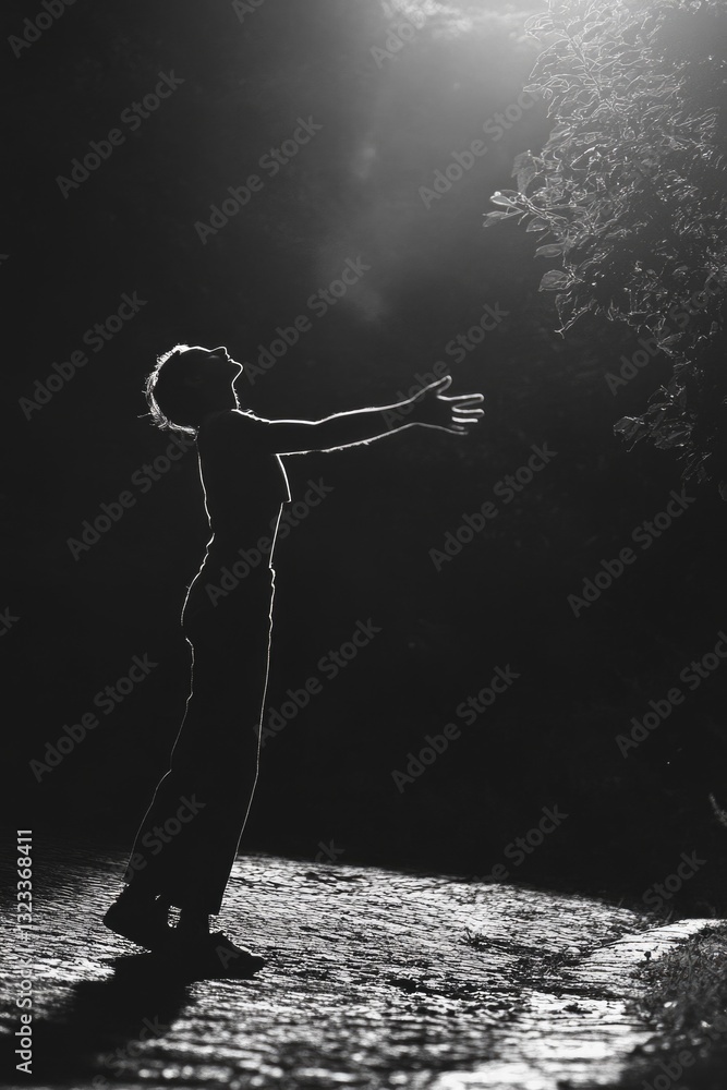 Poster a silhouette of a person stands out in the dark, with only a hint of light in the background