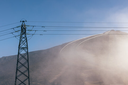 Power line in foggy mountain landscape under clear sky