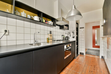A contemporary kitchen featuring black cabinetry and elegant fixtures, highlighting a minimalist and functional design aesthetic.