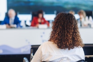 Audience at the modern conference hall listens to panel discussion, people on a congress together...