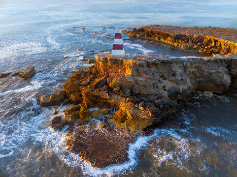 Rugged coastline with a monument on a rock ledge