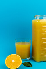 Glass of orange juice in glass close-up. Cut oranges on the table.
