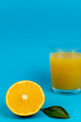Glass of orange juice in glass close-up. Cut oranges on the table.
