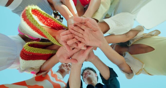 Happy people, hands together and huddle with applause for motivation below for unity, teamwork or mission. Low angle, group or circle with piling or stack in solidarity for community development