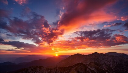 Obraz premium a breathtaking sunset with vibrant orange and pink hues blending into a dramatic sky filled with clouds creating a serene and picturesque scene