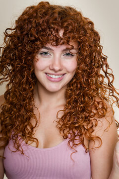 Portrait of smiling woman with beautiful long red curly hair