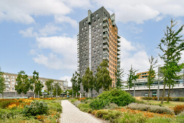A sleek, modern residential building surrounded by vibrant greenery and well-kept paths, showcasing...
