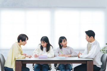 Fototapeta premium 勉強する二人の女の子と指導する男女