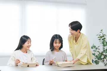 子どもにお弁当を提供する女性スタッフ