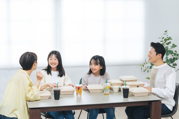 デリバリーフードを食べる女の子の家族