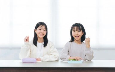 勉強しながらガッツポーズする二人の女の子