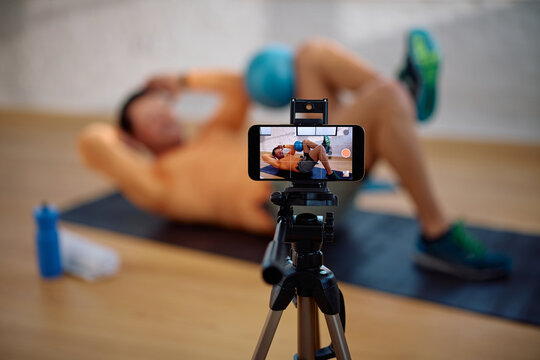 Close up of happy athlete live streaming fitness workout on social media.