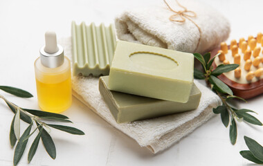 Natural olive oil soap, essential oil and white towels creating relaxing spa setting