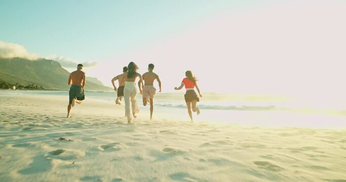 Back, people and friends running on beach for freedom, travel or excited for adventure. Outdoor, sunset and group at sea for holiday, tourism and students celebrate gap year with energy on vacation