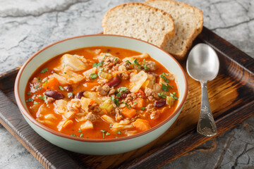 Winter Ground beef cabbage tomato soup with vegetables close-up in a bowl on the table. Horizontal