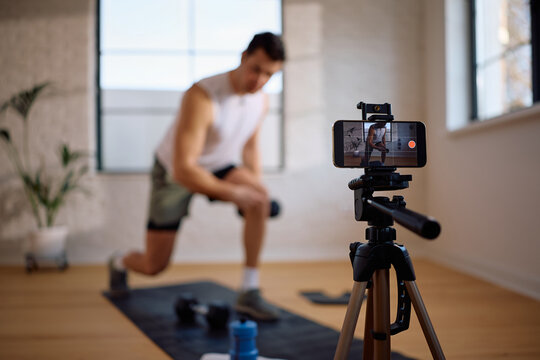Close up of fitness instructor recording exercise tutorial with smart phone.