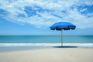 Sandy beach under blue umbrella offers cool shade.