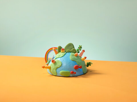 Colorful Miniature Earth Model with Rainbow and Trees