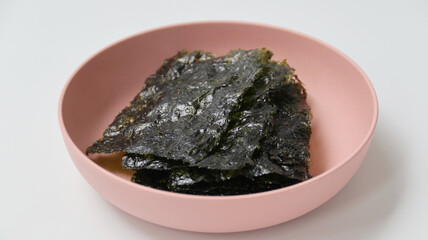 Japanese seaweed or nori on a pink bowl isolated on white background