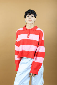 Studio portrait of androgynous model with striped shabby wool sweater