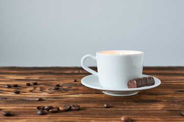 Cup of coffee with chocolate on wooden table. Coffee break concept