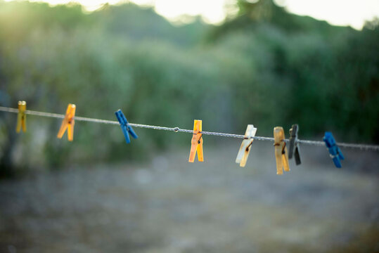 Colorful clothespins on a wire against a blurred natural background. Portugal