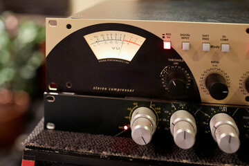 Close-up of a stereo compressor in a professional audio studio setting.