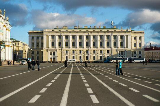 Wide open city square with people walking on lined pavement and historic building. St. Petersburg, Russia