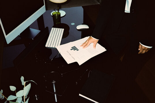 Hand of businesswoman on documents on office table