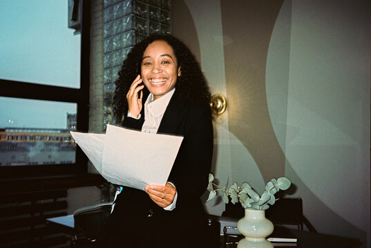 Portrait of smiling businesswoman with phone and documents
