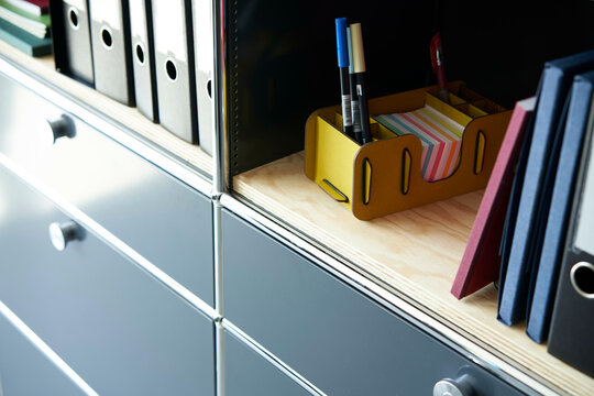 Office shelves with document folders, sticky notes, and pens organized neatly.