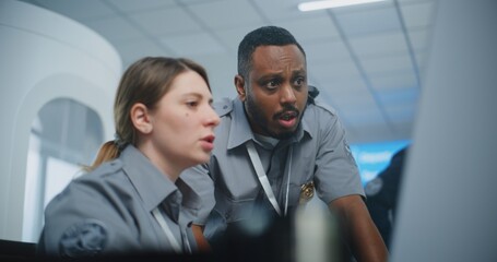 Airport Staff at Security Checkpoint: Two Multiethnic Security Officers in Uniform Talking,...
