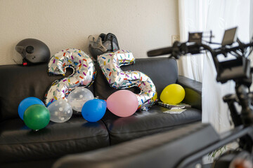 Silver number balloons for 25th birthday with colorful balloons and a brand new bicycle in a living room. Arnhem, Netherlands
