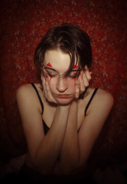 Young Person Putting on Red Jester Makeup