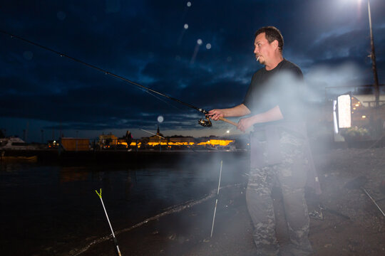Angler catching cuttlefish at night