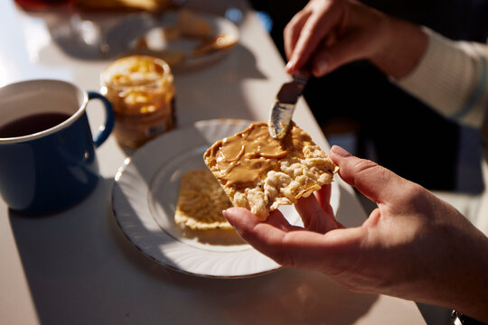 Spreading peanut butter on bread