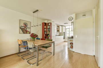 A contemporary dining area featuring a sleek table, stylish chairs, and vibrant decor, with ample natural light illuminating the space.