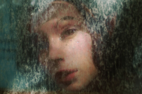 Portrait of an Elf girl throw the dirty window