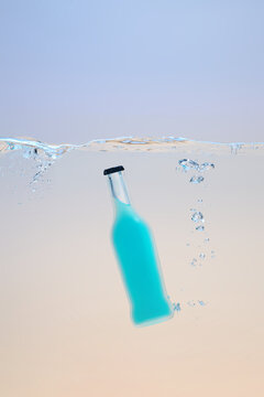 Refreshing Blue Bottle Splashes Through Clear Water Surface