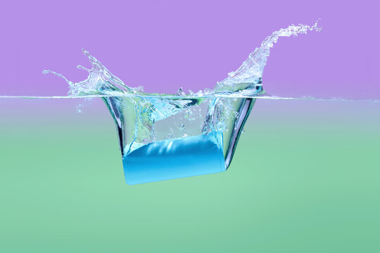 Splashing Block of Ice in Water With Colorful Background