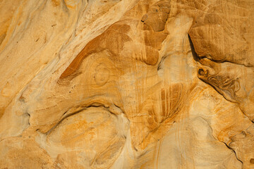 Natural texture background of sandstone rocks with lines, curves, prints in the As Amoeiras and Formosa beach cliffs in Santa Cruz, Portugal.