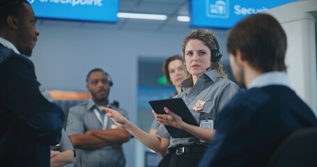 Airport Security System: Female TSA Officer with Tablet Computer Wearing Headset Instructs Airport...