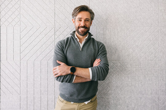 Confident businessman standing against textured wall